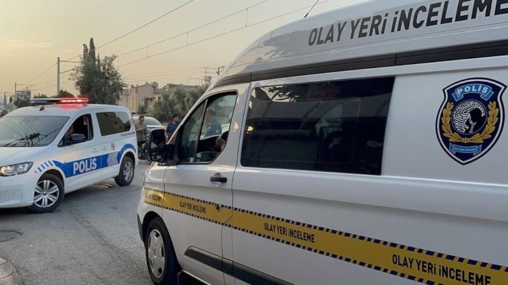 Olay yeri inceleme aracı ve polis ekiplerinin bulunduğu genel olay yeri görüntüsü.