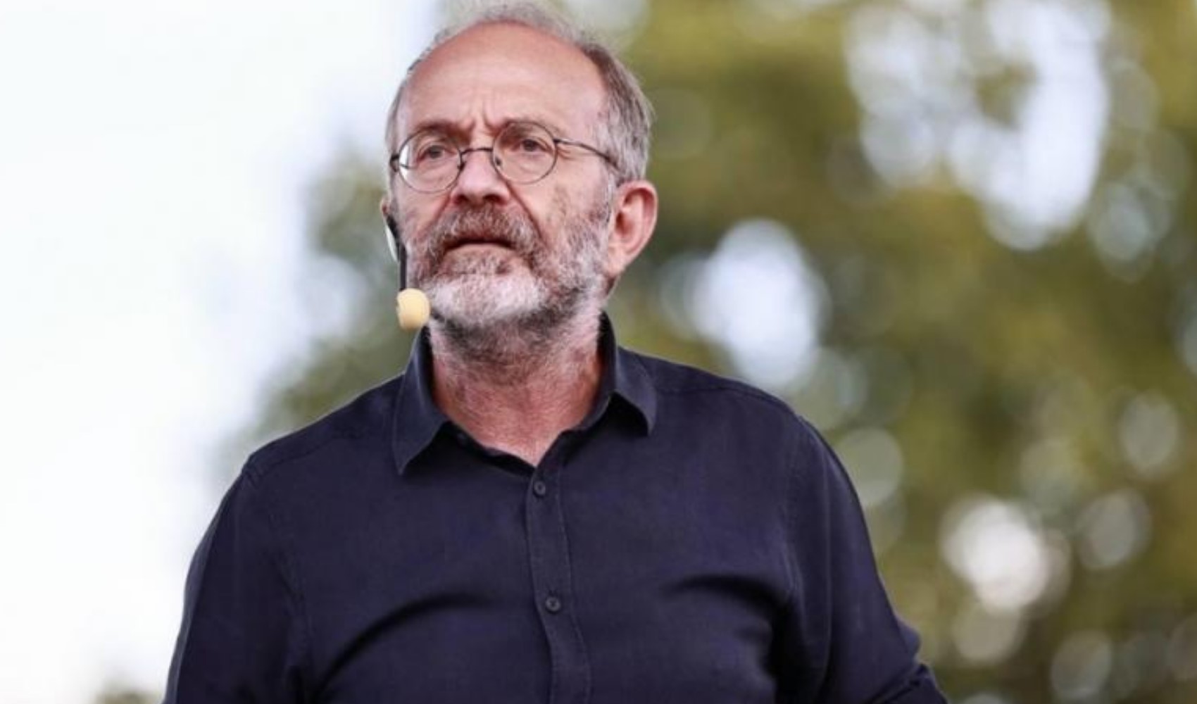 Kemal Okuyan açık alanda mikrofonla konuşurken görülüyor.
