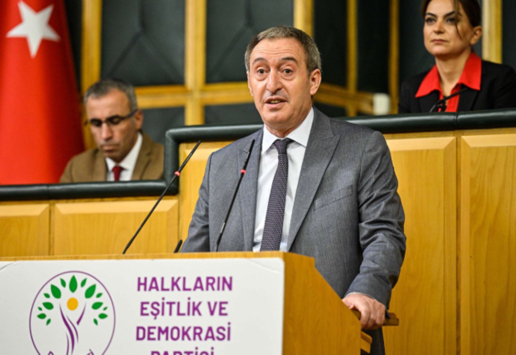 Tuncer Bakırhan bir parti kürsüsünde konuşurken görülüyor.