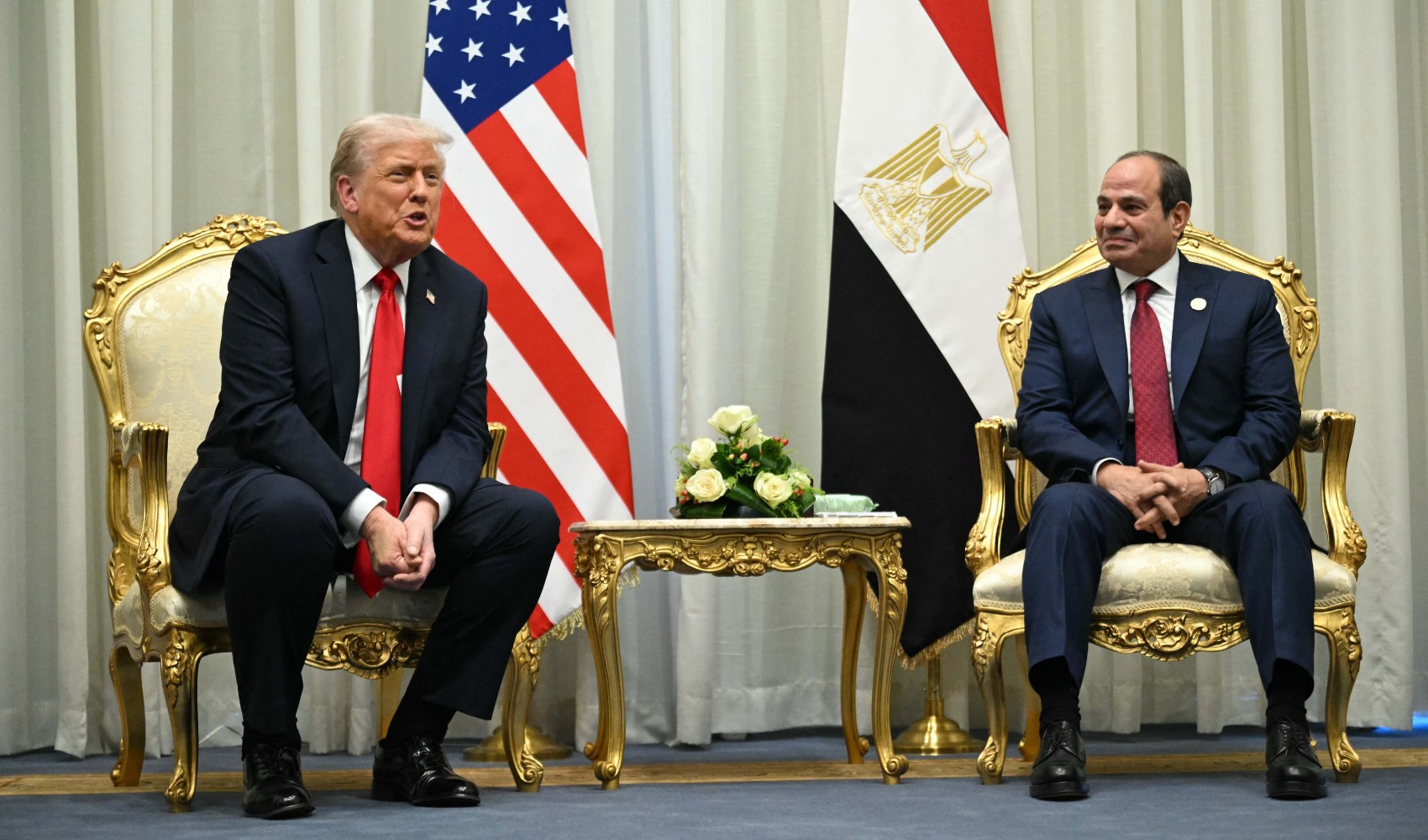Abdülfettah es-Sisi ve Donald Trump, ABD ve Mısır bayraklarının önünde yan yana otururken görülüyor.