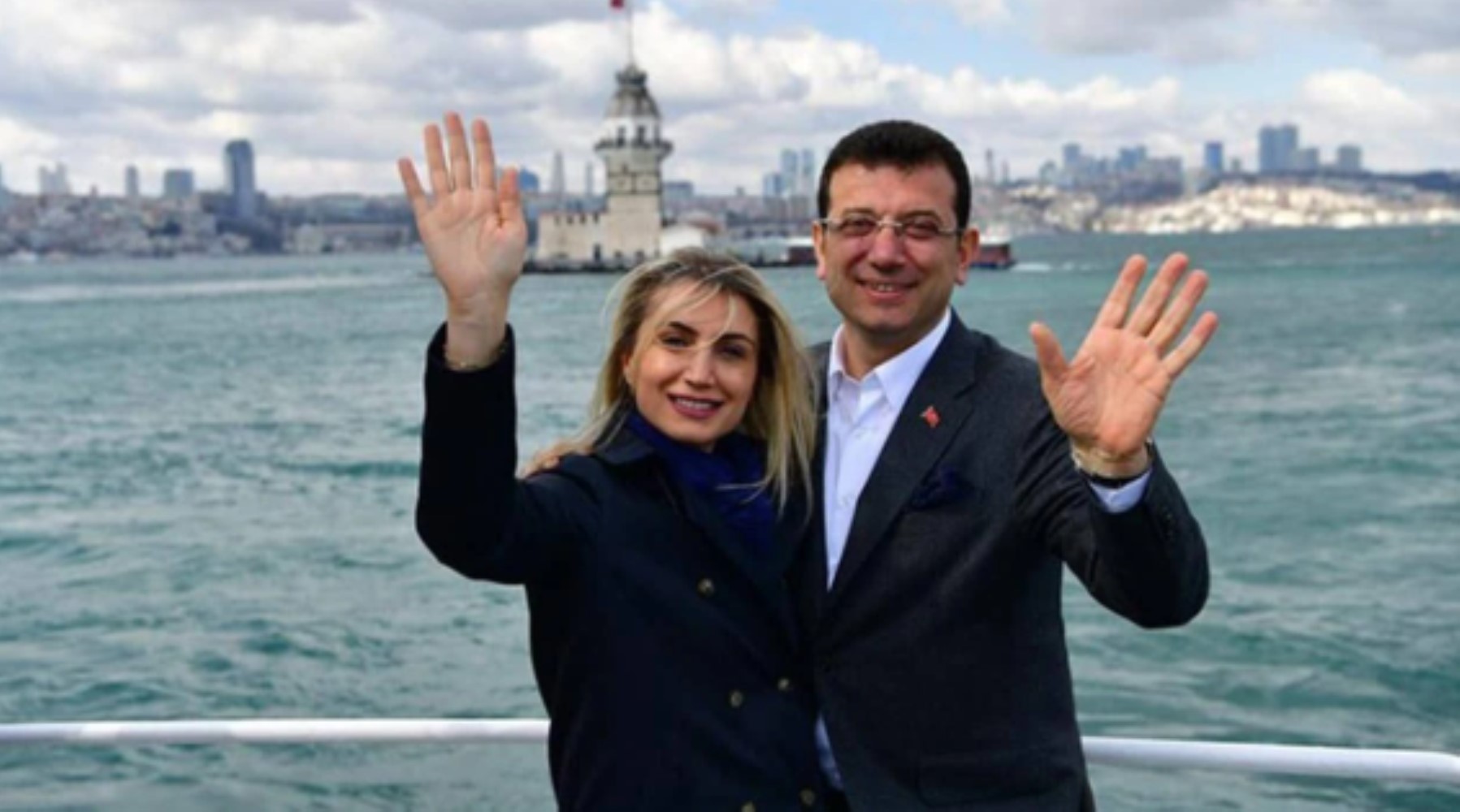 Ekrem İmamoğlu ve Dilek Kaya İmamoğlu’nun İstanbul’da deniz kıyısında el salladığı fotoğraf.