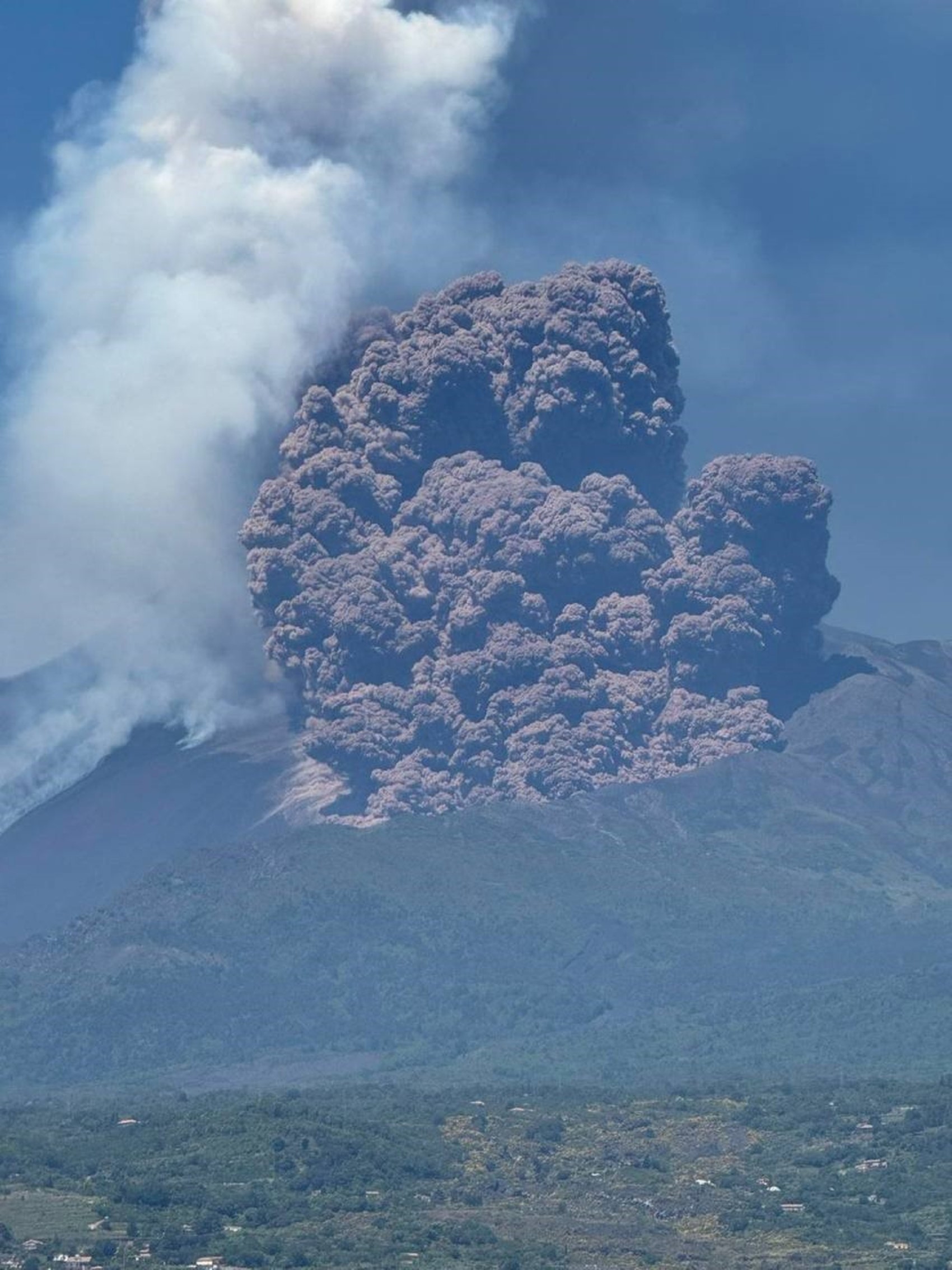 Etna Yanardağı üzerinde yükselen yoğun gri kül bulutunun yakından görünümü.