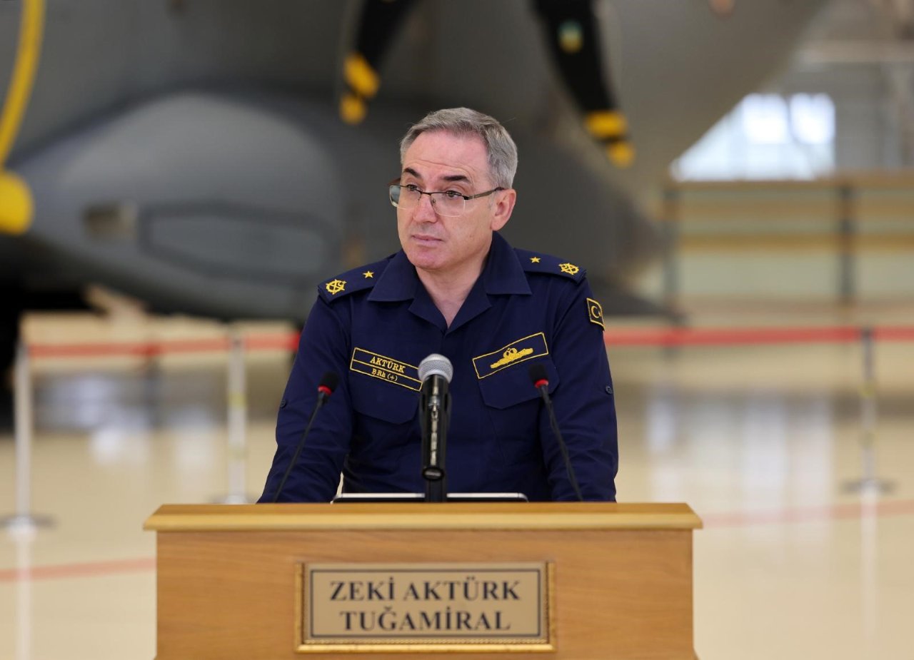 Tuğamiral Zeki Aktürk, mikrofonların bulunduğu kürsüde açıklama yaparken görülüyor.