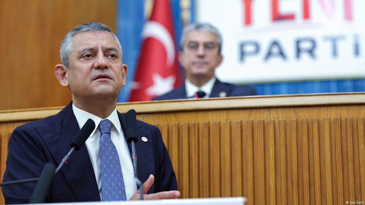 Yeni Parti Genel Başkanı Özgür Özel'in kürsüde konuşma yaptığı bir toplantı görüntüsü.