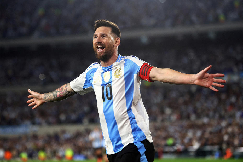 Lionel Messi with his arms open on the field in an Argentina jersey.