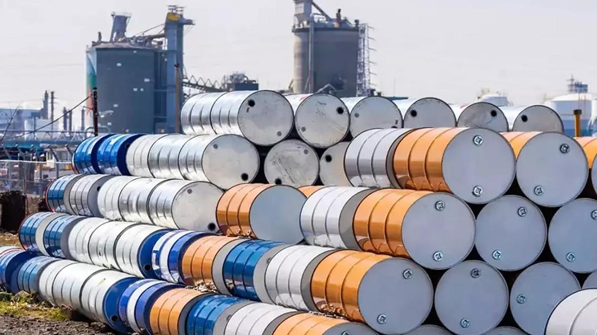 Sanayi tesisleri önünde üst üste dizilmiş metal yakıt varilleri.