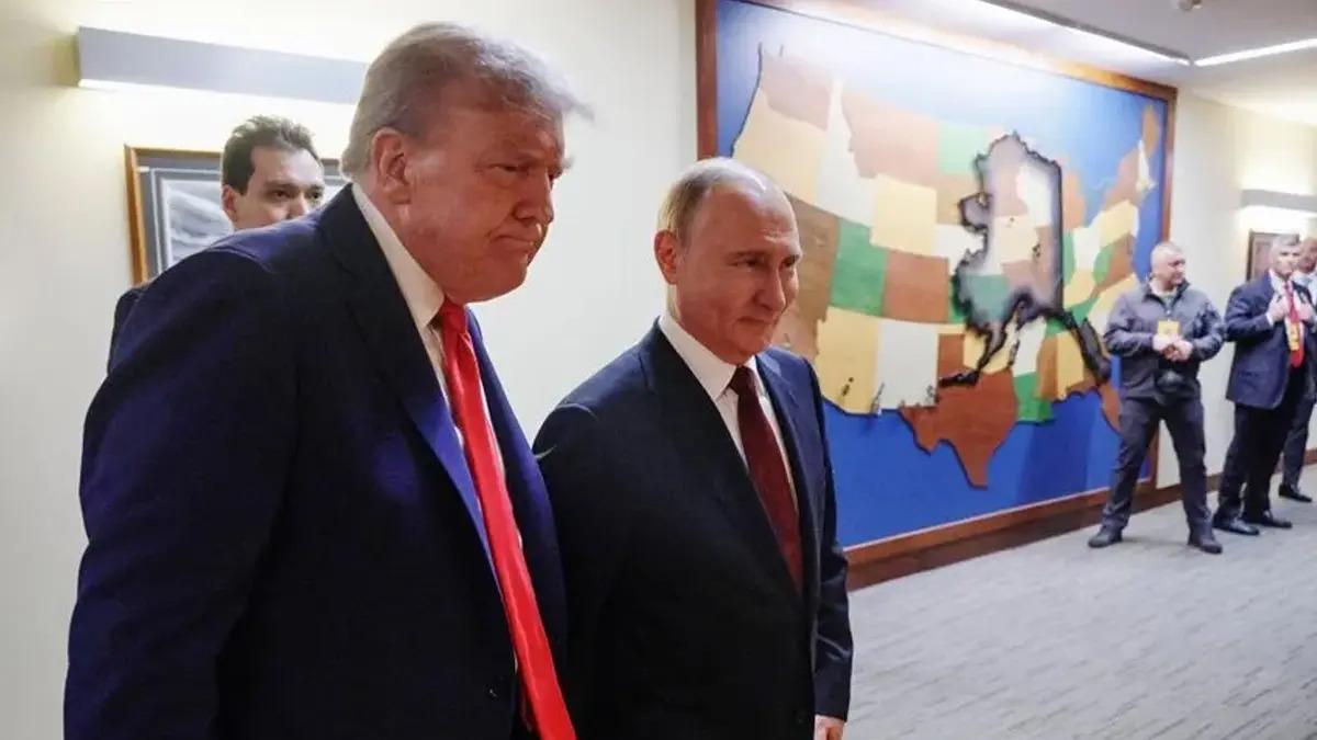 Donald Trump ve Vladimir Putin’in bir koridorda yan yana yürüdüğü görüntü.