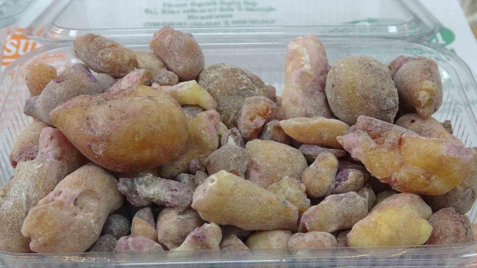 Plastik kap içinde sarı ve pembe tonlarda çam sakızı parçaları.