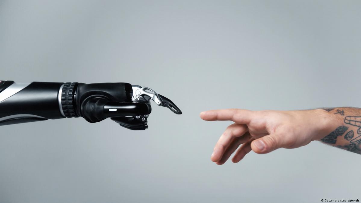 A robot hand and a human hand reaching out to touch each other