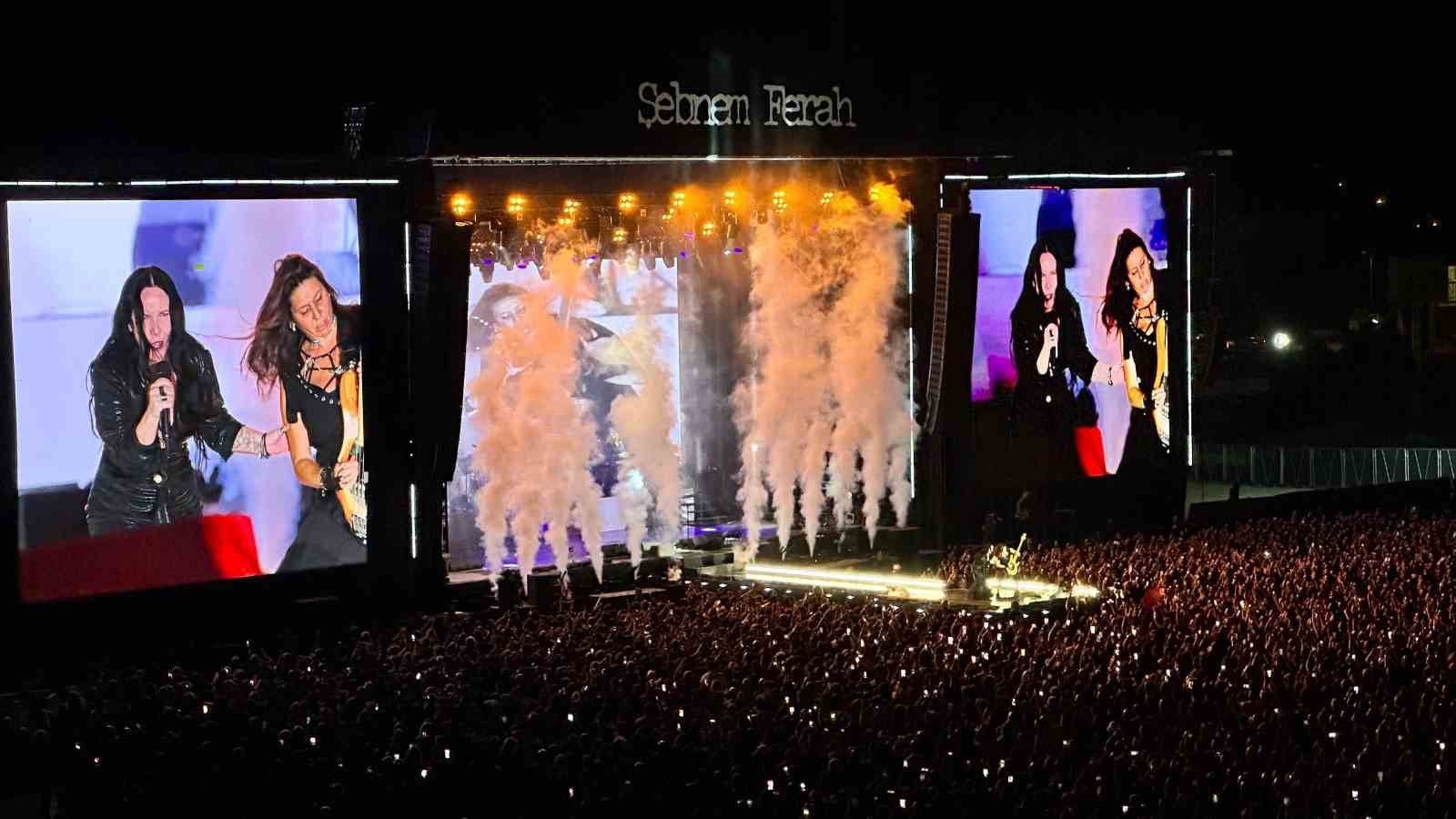 Şebnem Ferah konserinde sahne, ışıklar, duman efektleri ve kalabalık izleyici kitlesi görülüyor.
