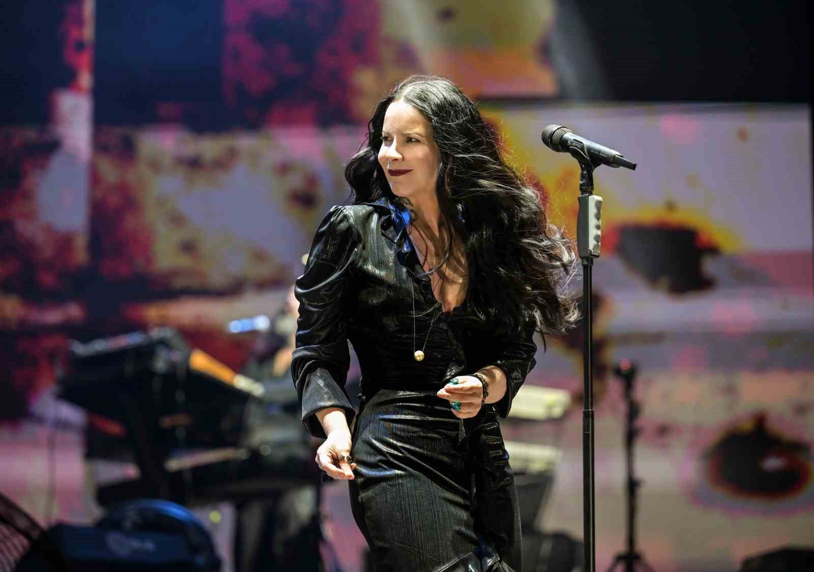 Şebnem Ferah sahnede mikrofonun yanında, konser ışıkları altında görülüyor.