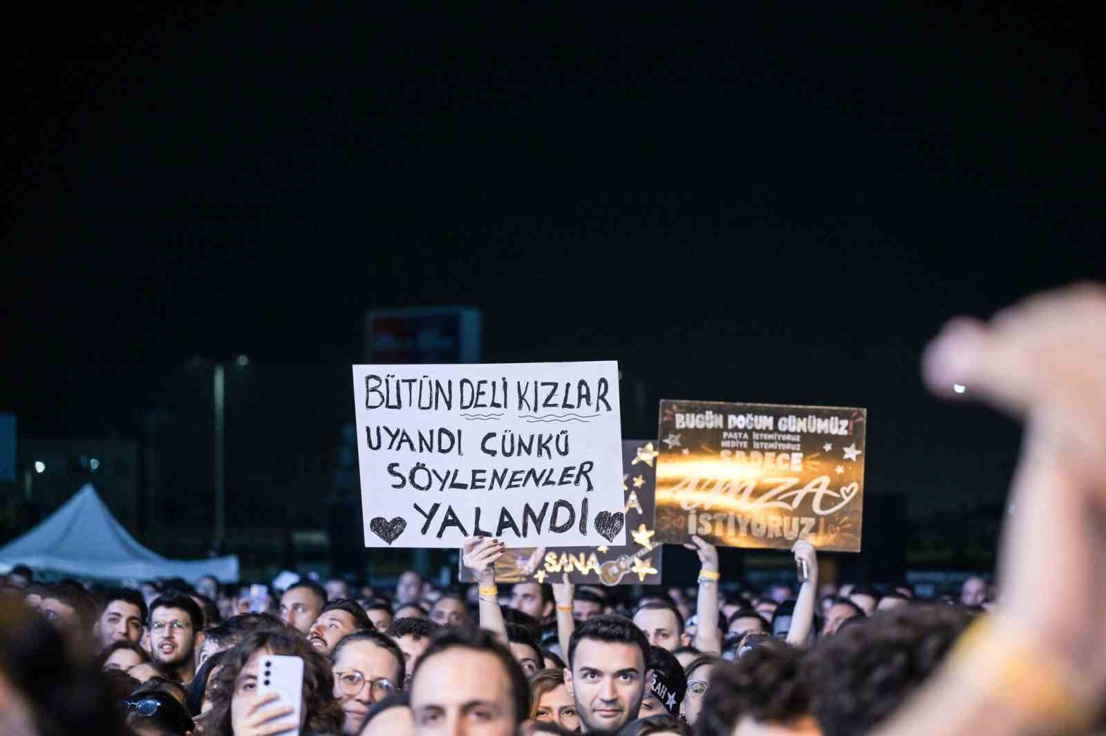 Kalabalık içinde Şebnem Ferah şarkılarına gönderme yapan pankartlar görülüyor.