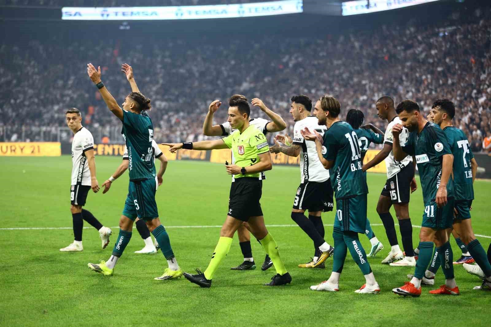 Hakem ve futbolcular Beşiktaş-Kocaelispor maçında sahada görülüyor.