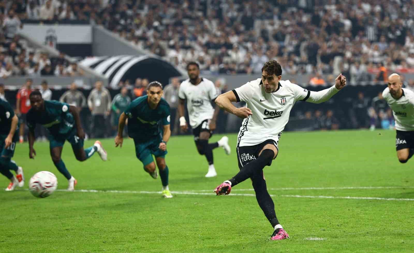 Beşiktaşlı futbolcu penaltı vuruşu yaparken rakip oyuncular ceza sahası dışında bekliyor.