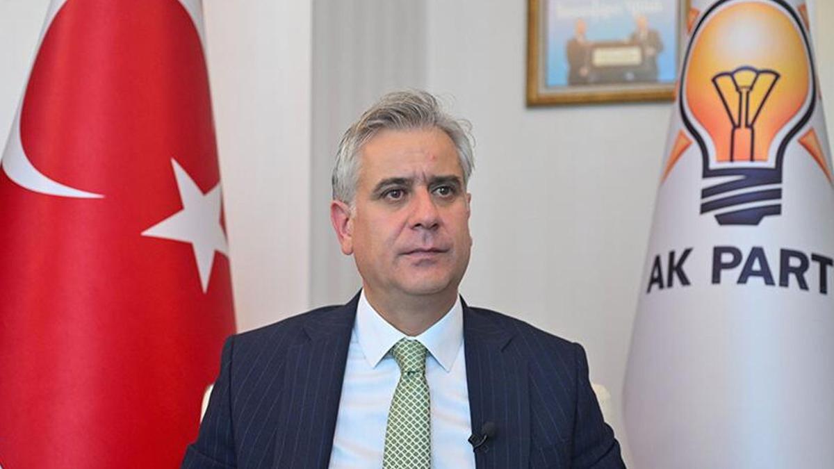 Hasan Basri Yalçın che parla davanti alla bandiera turca e alla bandiera dell'AK Party.
