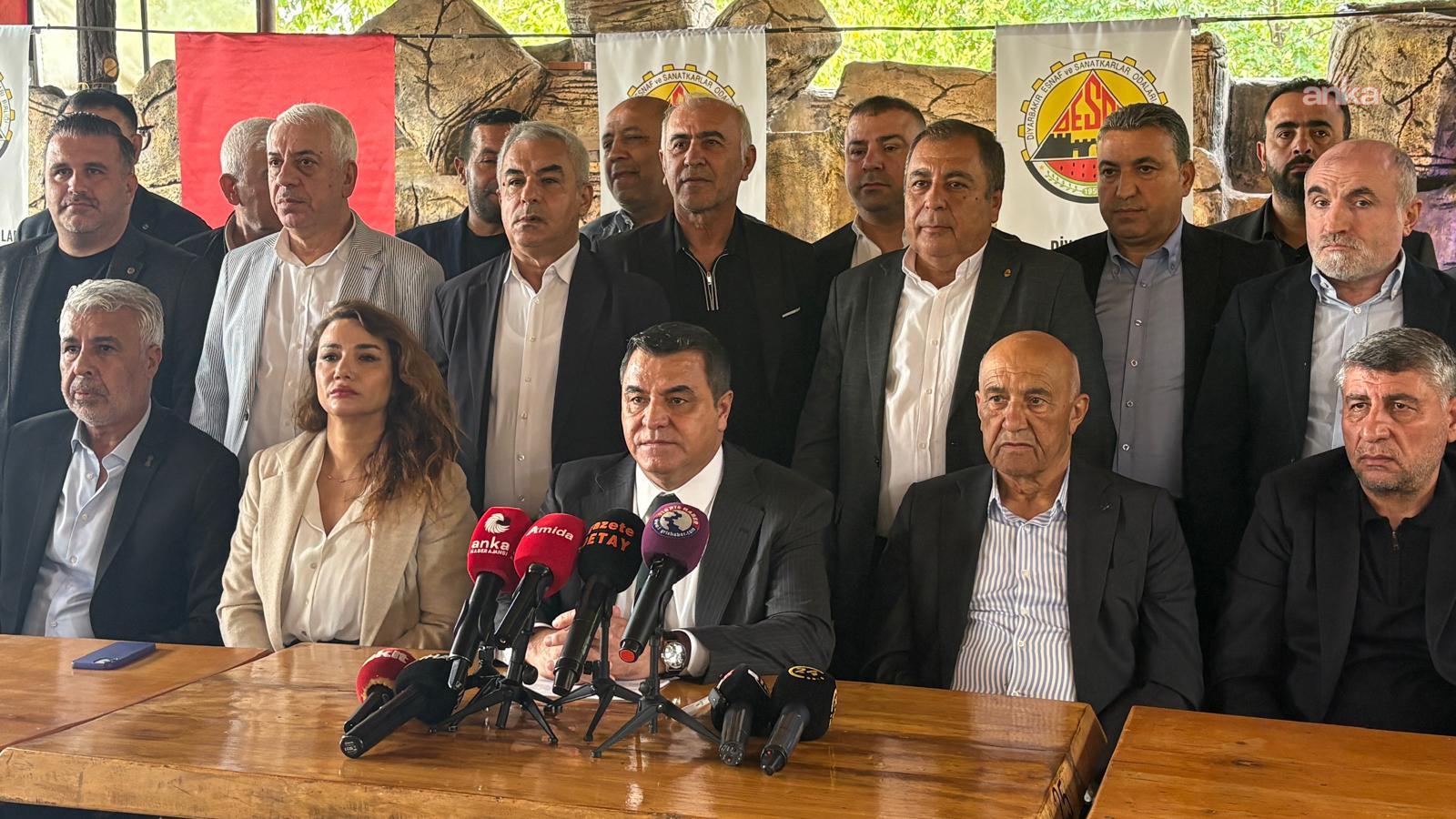 Diyarbakır’da DESOB logosunun önünde, masa etrafında oturan ve ayakta duran esnaf temsilcileri basın toplantısında görülüyor.
