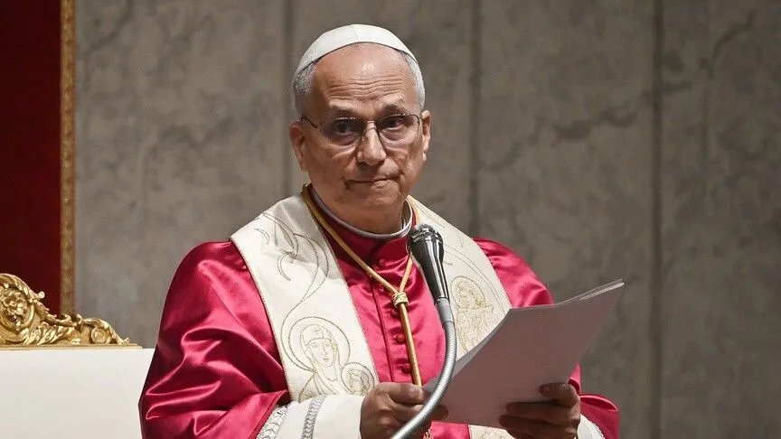 Papa 14. Leo mikrofon önünde elindeki metni okurken görülüyor.