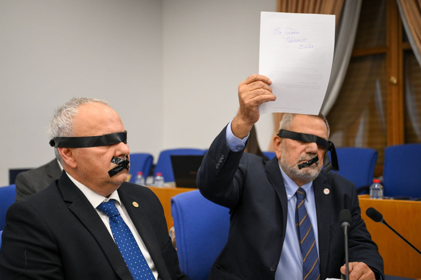 TBMM komisyon salonunda gözleri ve ağızları siyah bantla kapatılmış milletvekilleri protesto gerçekleştiriyor.