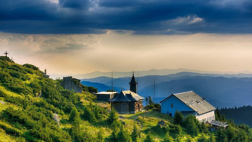 Dağlık ve yeşil bir bölgede manastır yapıları ve geniş manzara.