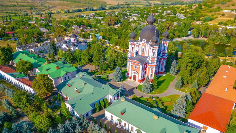 Yeşil alanlar içinde kubbeli tarihi bir manastır kompleksinin havadan görünümü.