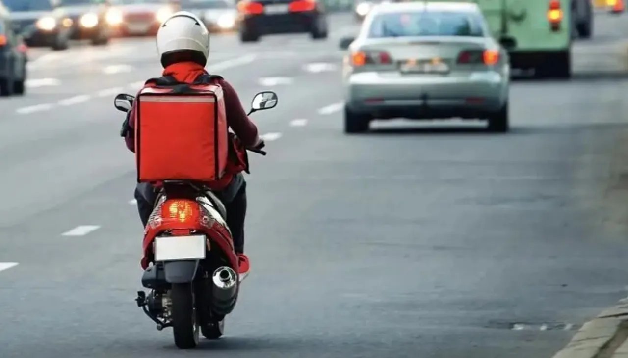A motorcycle courier driving in traffic.