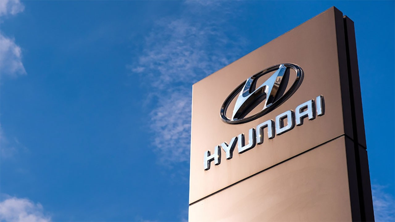 A sign featuring the Hyundai logo against a blue sky.