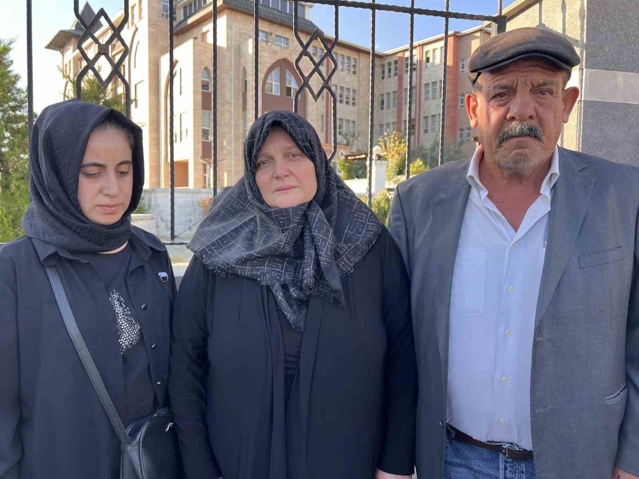 Three people identified as relatives of Mesut Kazancı in front of the courthouse.