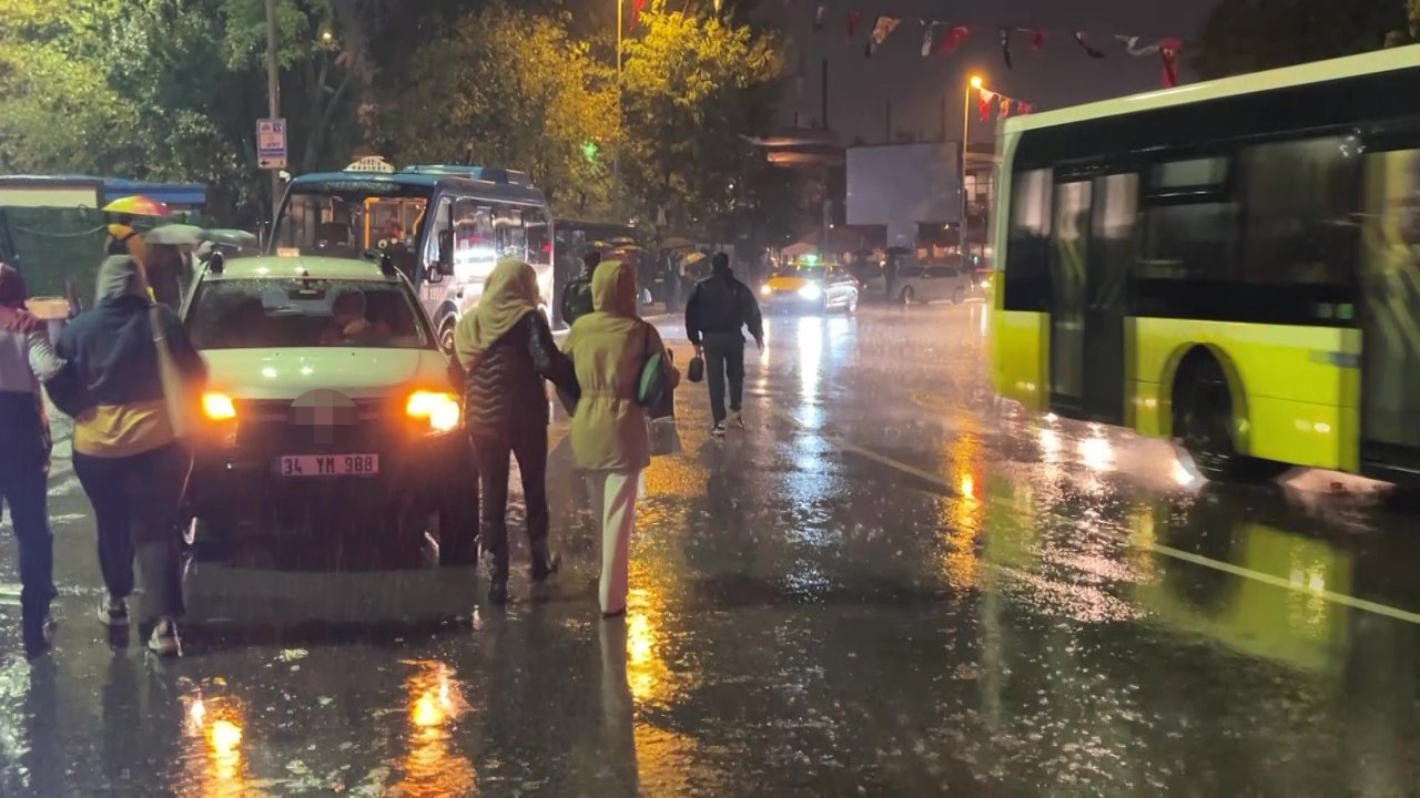 Yağmur altında trafikte ilerleyen araçlar, otobüs ve yayalar.