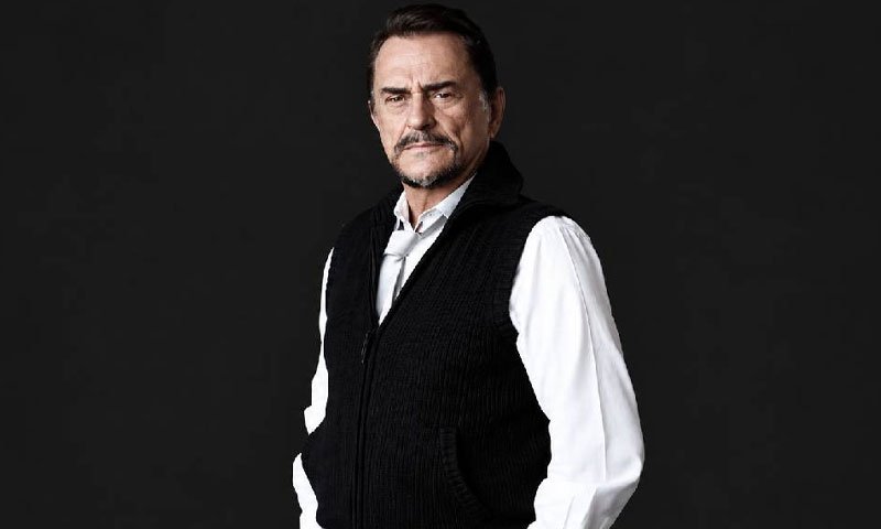 Siyah fon önünde poz veren Alpay Nazikioğlu portresi.