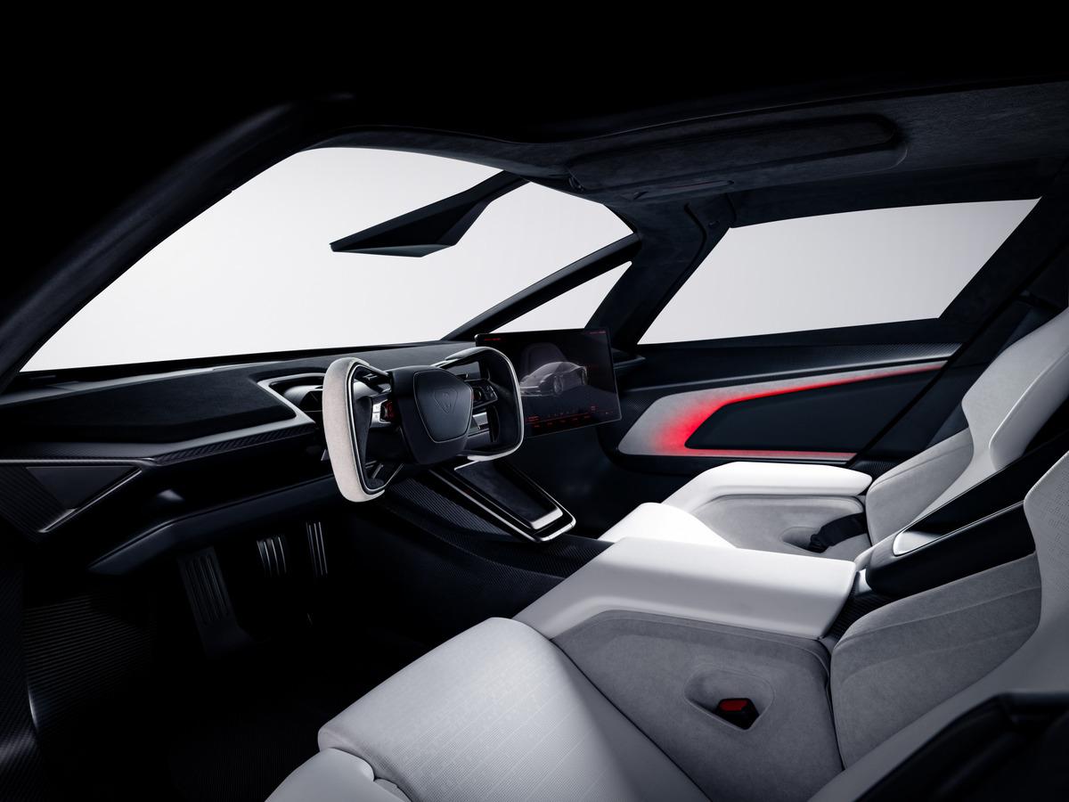 Interni della nuova Tesla Roadster; sono visibili il volante, lo schermo, i sedili anteriori e l'illuminazione ambientale rossa.