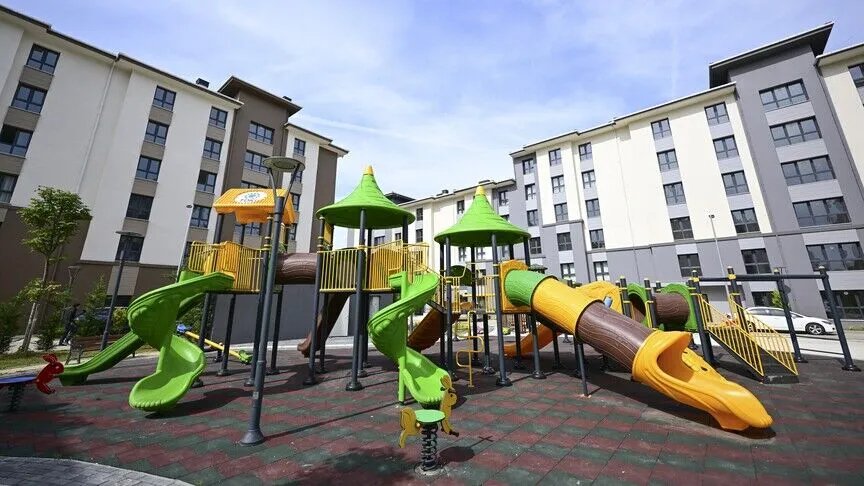 Social housing complex with a children's playground between residential blocks.