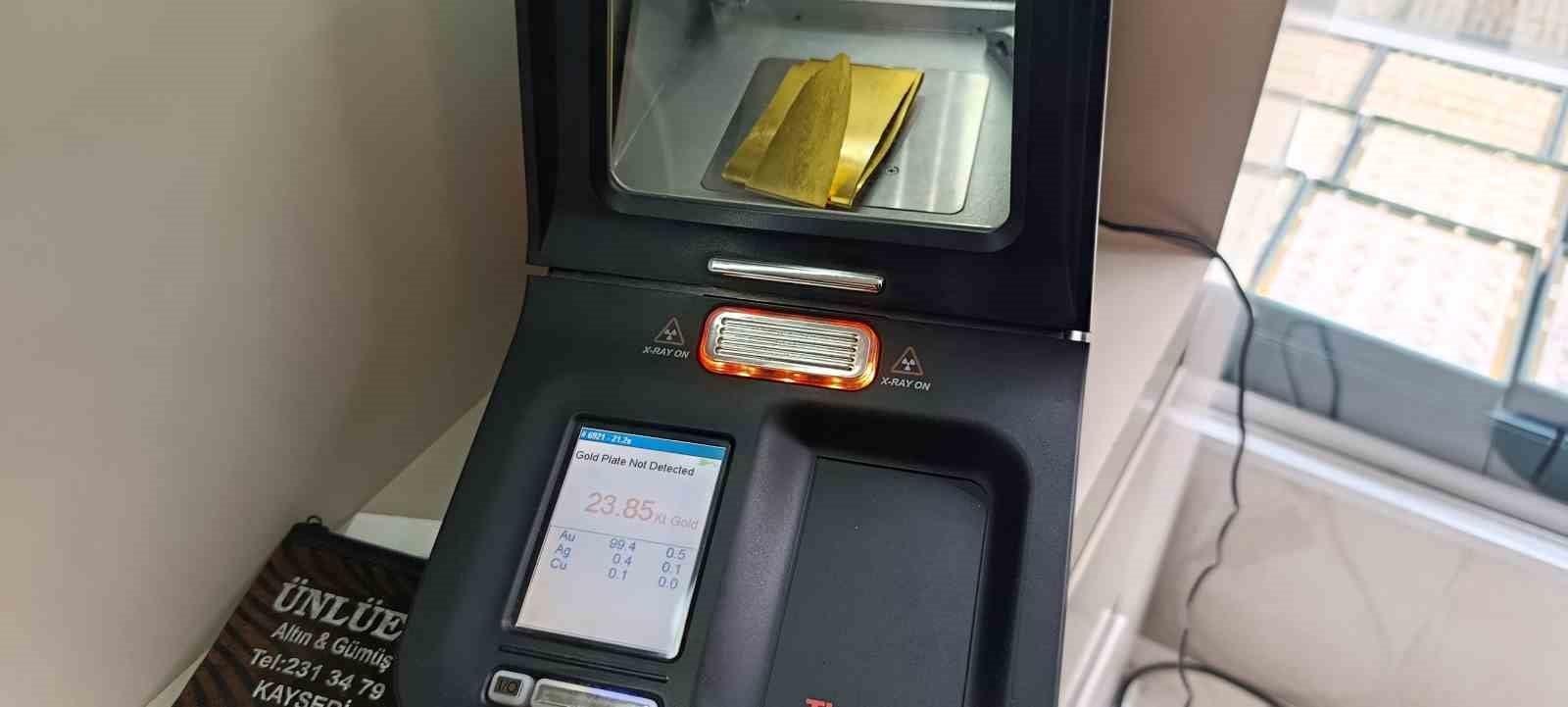 A gold karat measurement device and gold pieces being checked inside the device are seen at a jeweler's.