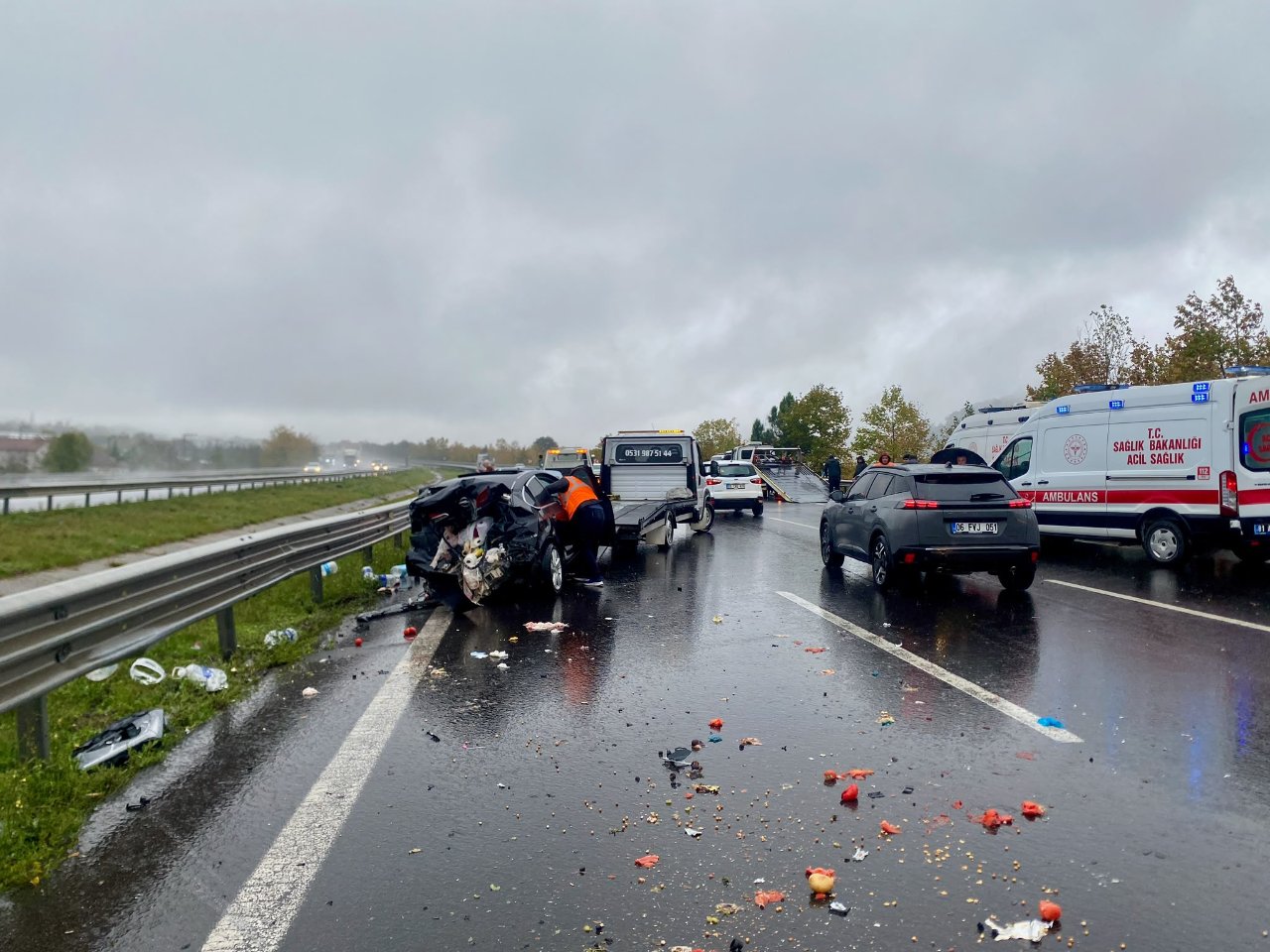 Yağışlı havada otoyolda meydana gelen trafik kazasının ardından olay yerindeki araçlar ve ambulanslar.