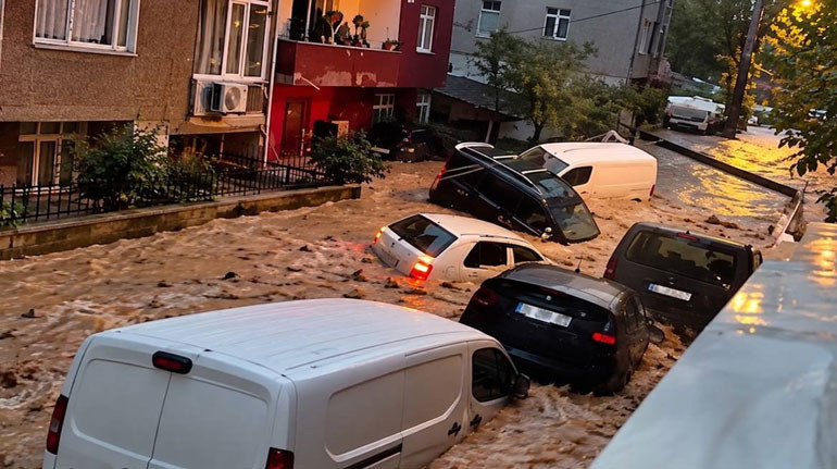Yoğun su akışı içinde kalan araçların bulunduğu sokak.