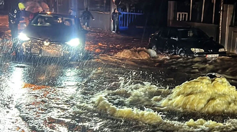 Gece saatlerinde su baskını yaşanan yolda araçlar.