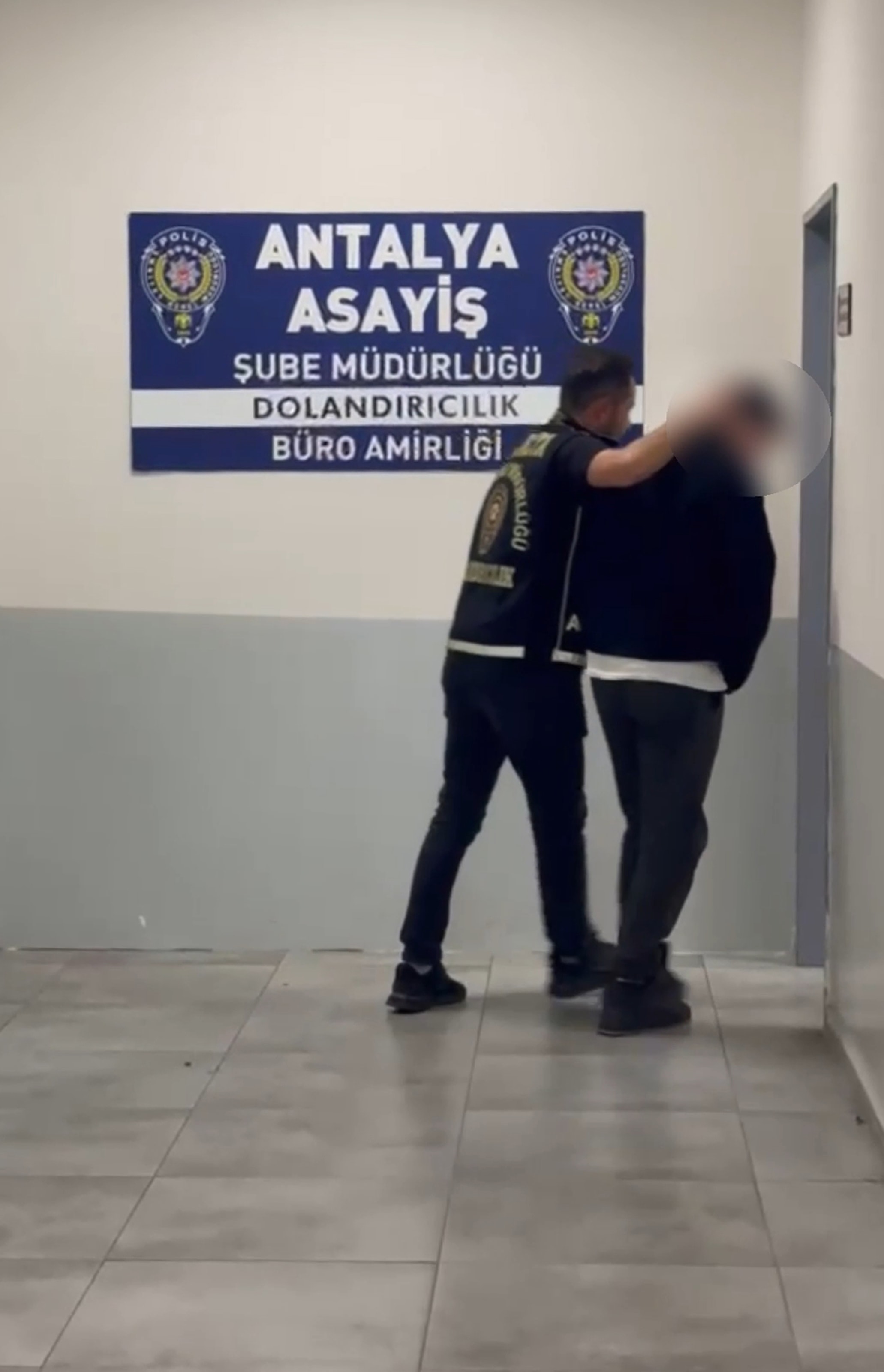 Antalya Asayiş Şube Müdürlüğü Dolandırıcılık Büro Amirliği önünde polis eşliğinde götürülen şüpheli.