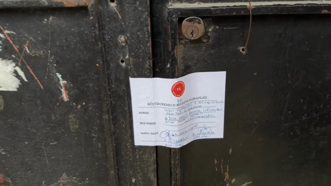 Mühürlenen bina kapısına asılmış belediye tutanağı.