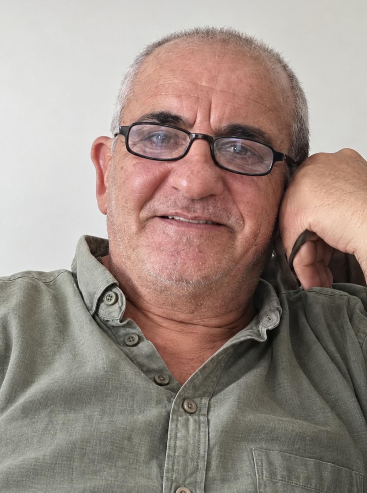 Ahmet Derin olduğu belirtilen gözlüklü bir erkeğin portre fotoğrafı.