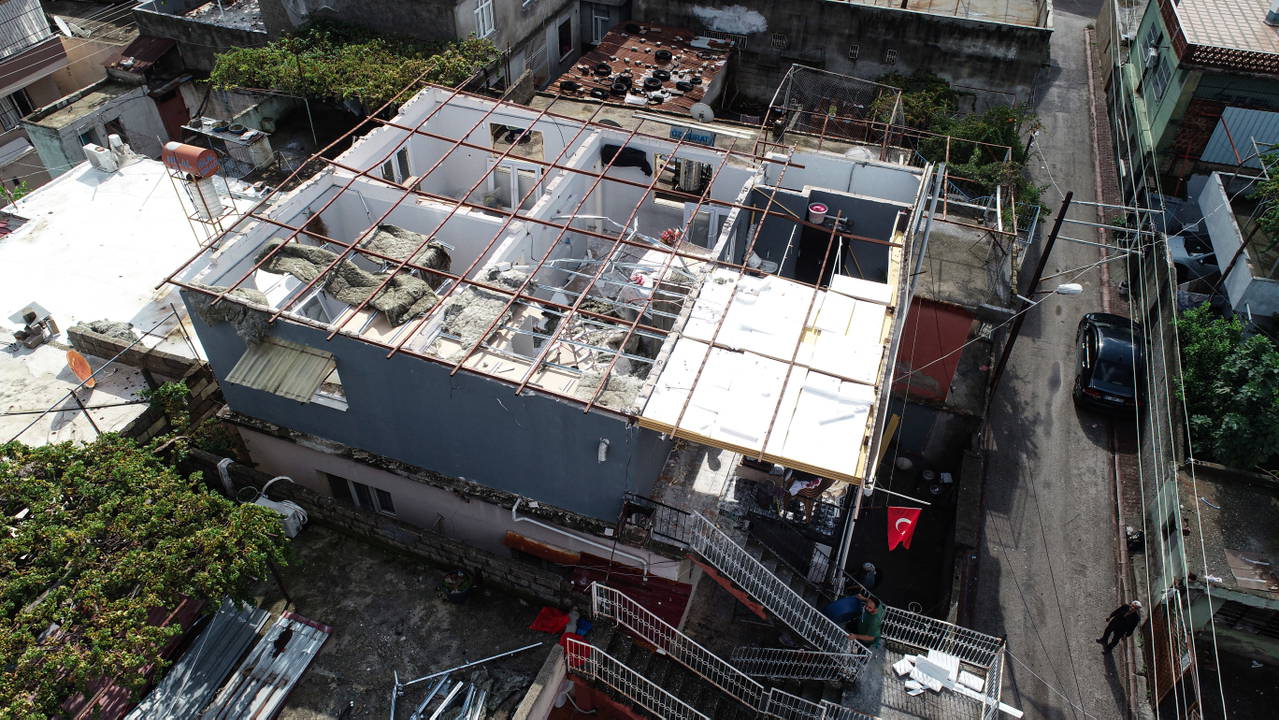 Adana Yüreğir’de çatısı uçan 3 katlı evin üstten çekilmiş görüntüsü.