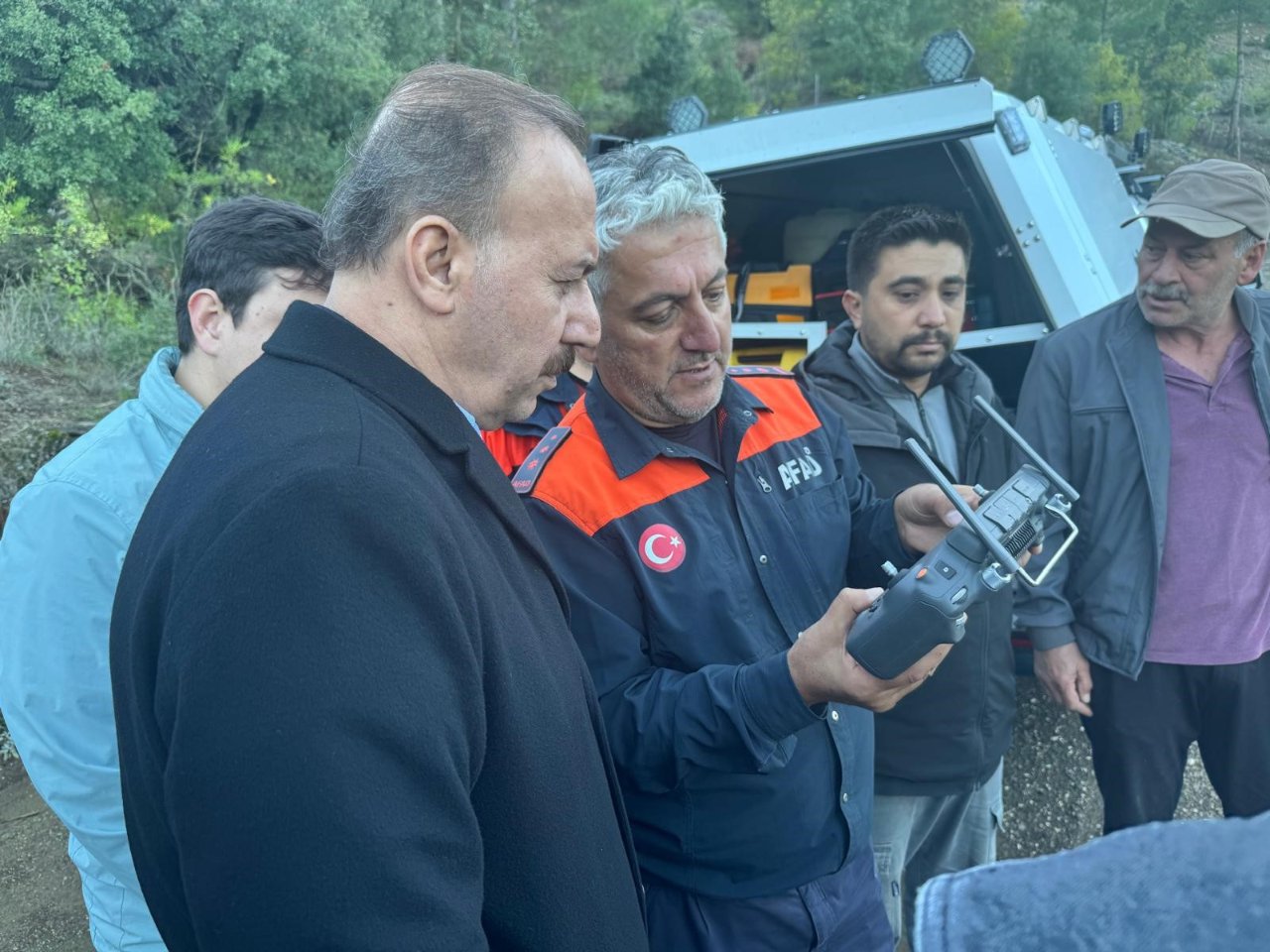 On voit les équipes de recherche et de sauvetage travailler sur le terrain avec des radios et du matériel.