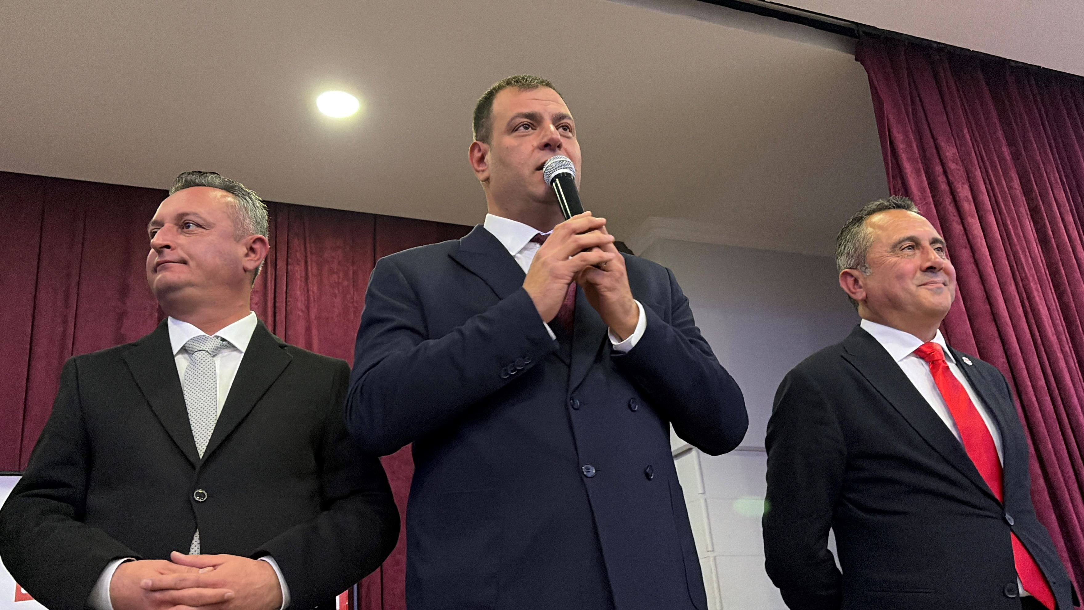 Mikrofonla konuşan İsmail Dündar ve yanında duran partililer.