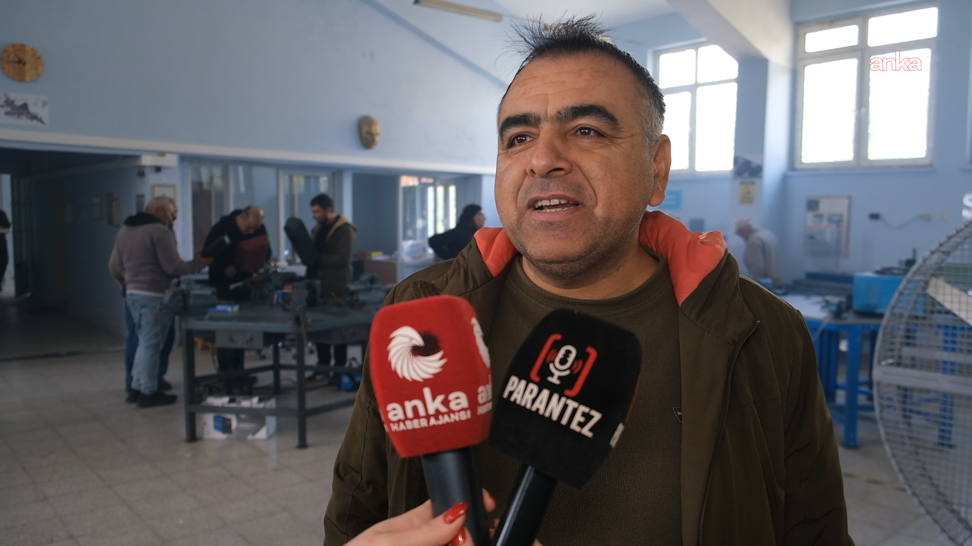 Bir yetkili, kaynak atölyesinde basın mensuplarına açıklama yapıyor.