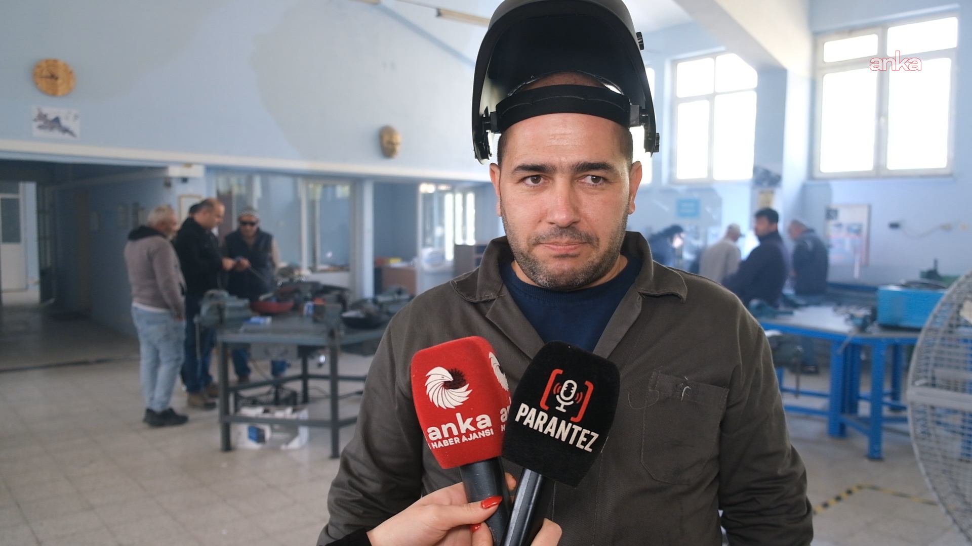 Kaynak maskesi başında olan eğitmen, atölyede mikrofonlara açıklama yapıyor.