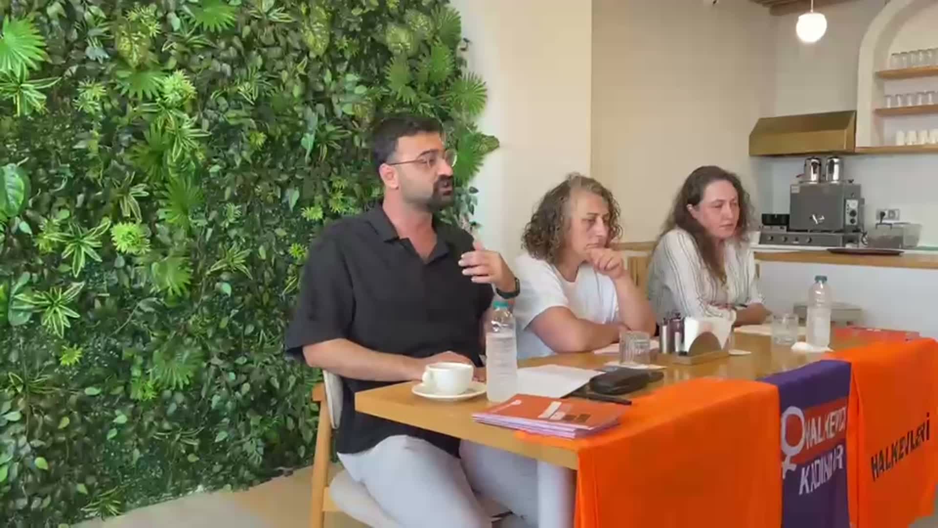 Hopa’daki toplantıda masada oturan konuşmacıların ve Halkevleri pankartlarının görüldüğü kare.