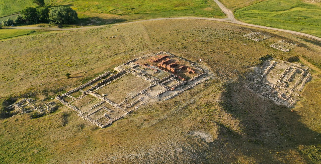 Luftaufnahme der Ruinen der antiken Stadt Sarissa in der weiten Landschaft.