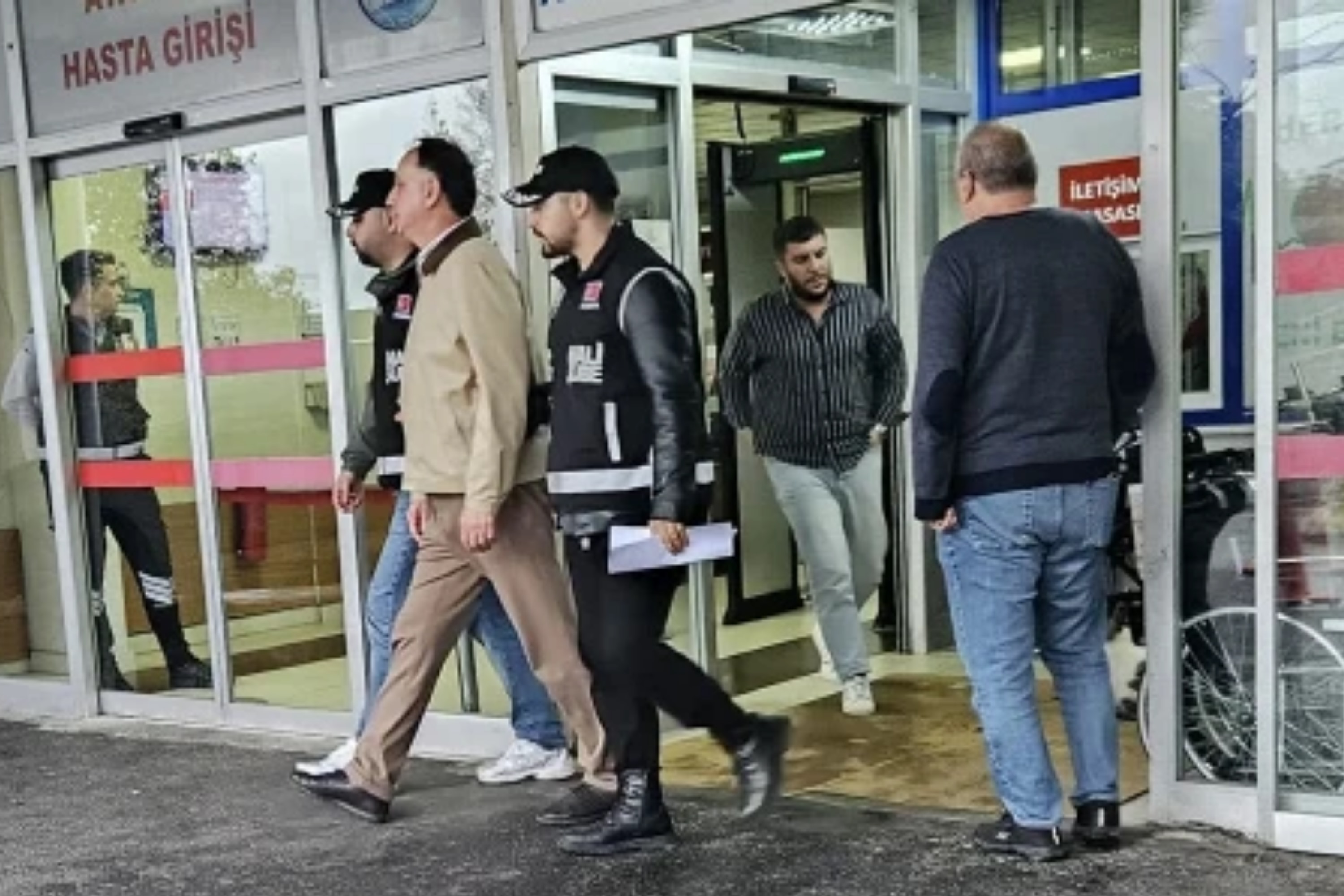 Polislerin de bulunduğu bir bina girişinde soruşturma sürecine ilişkin görüntü.