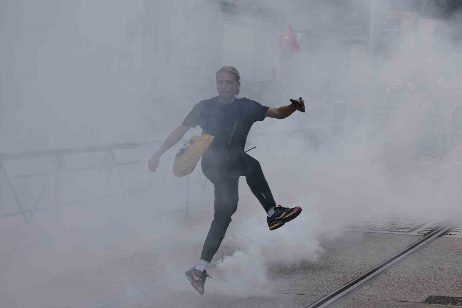 Yoğun gaz bulutu içinde koşan bir protestocu görülüyor.