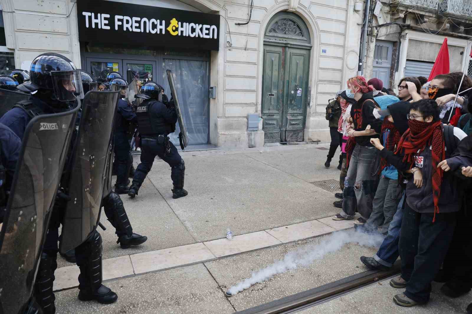 Bir cadde üzerinde çevik kuvvet polisleri ve protestocu öğrenciler görülüyor.