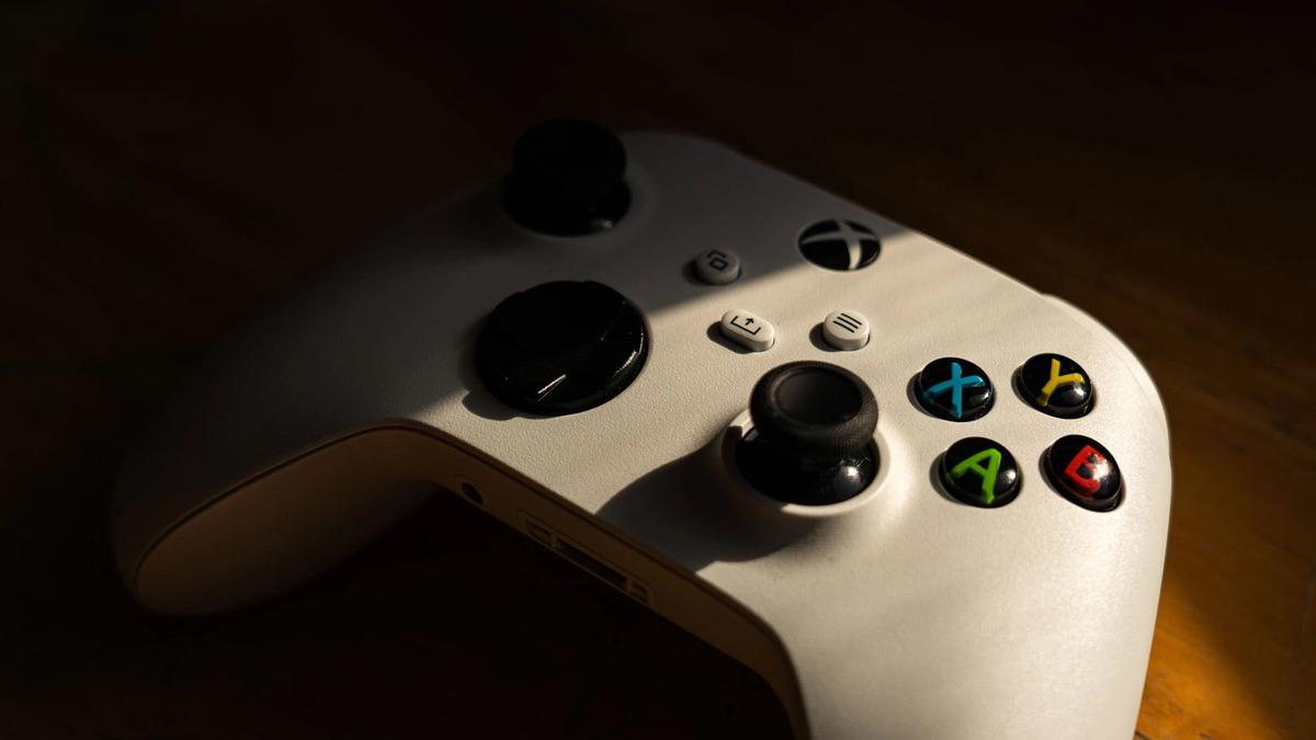 Loş ışıkta bir Xbox kontrolcüsü.