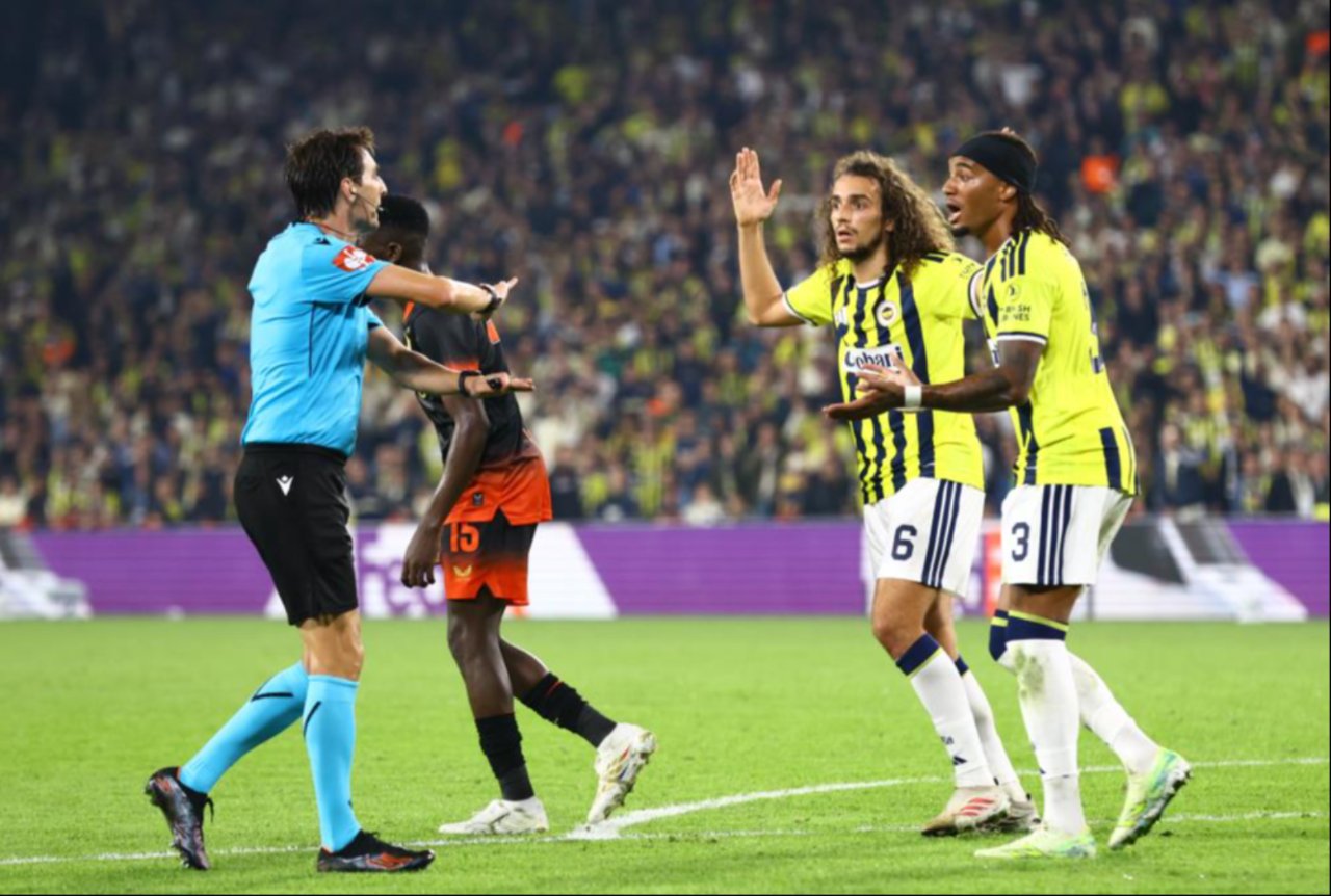 Fenerbahçeli oyuncuların hakemle konuştuğu, Slavia Prag futbolcusunun yanında bulunduğu maç anı.
